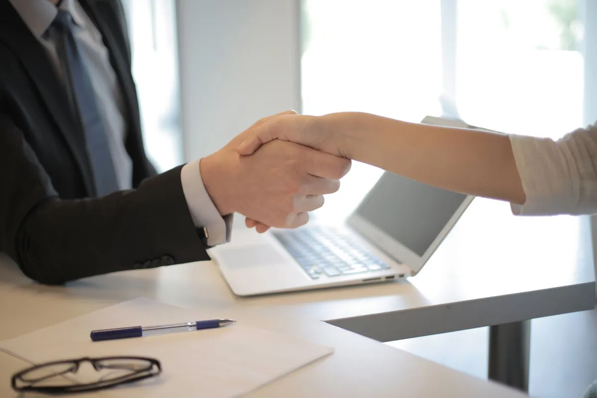 Conseiller France Travail présentant des aides à l'embauche à un employeur dans un bureau